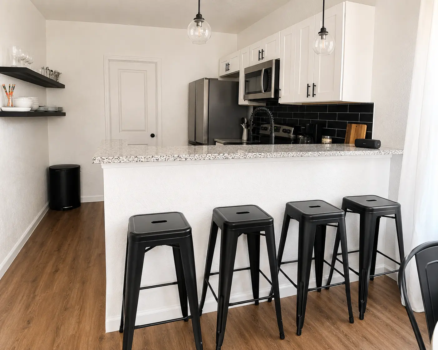 Kitchen bar with granite counter and black stools