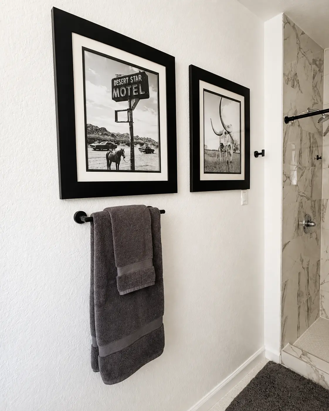 Framed black and white artwork in the primary bathroom